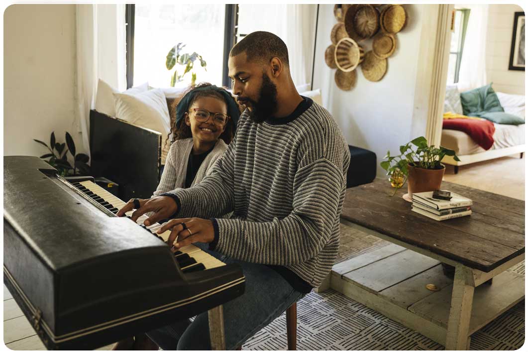 Man teaching his daughter piano