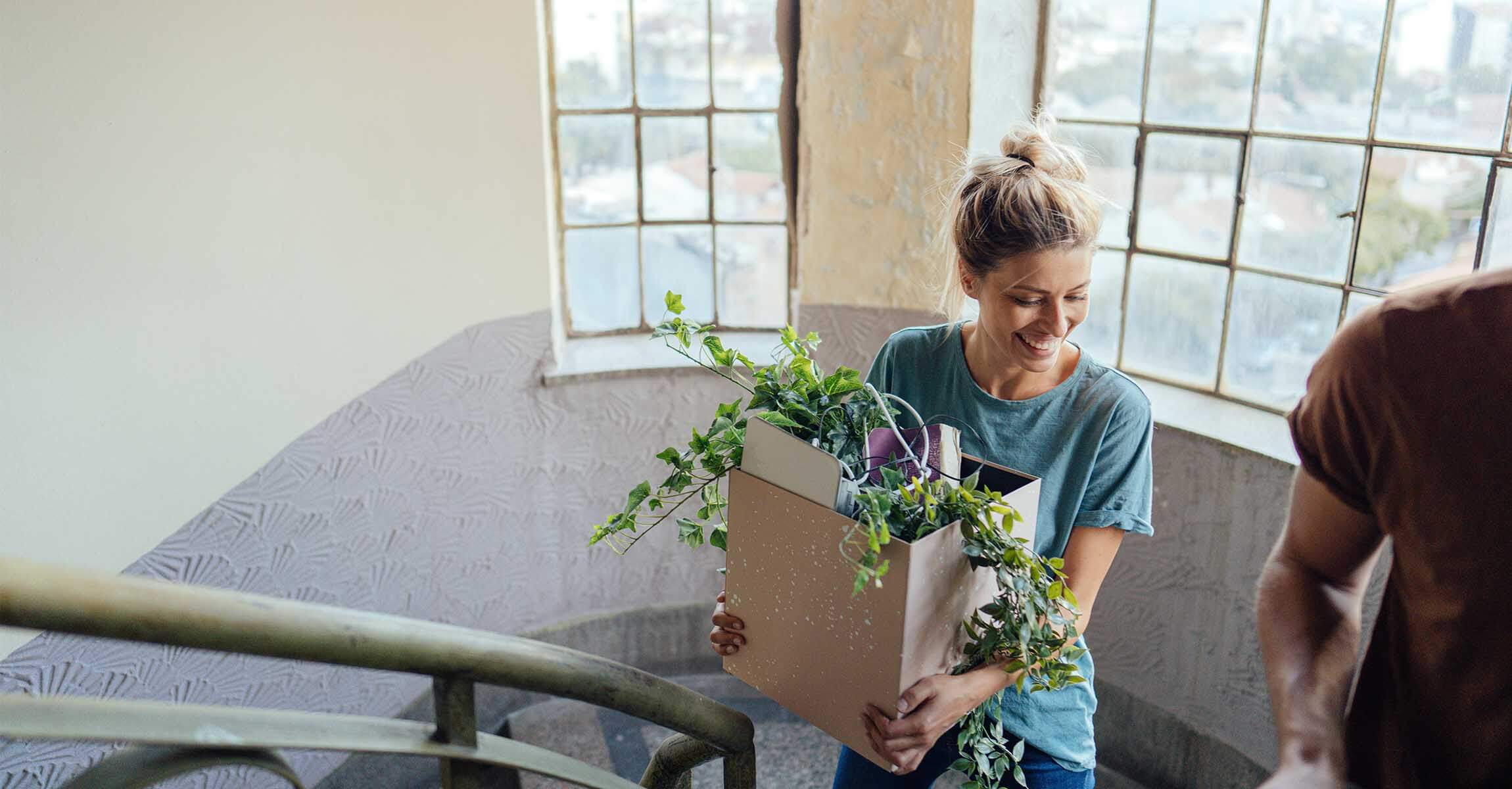 Smiling woman carrying moving box