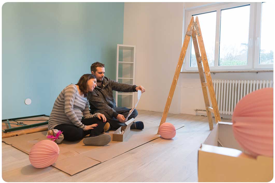 couple sitting on floor resting while decorating