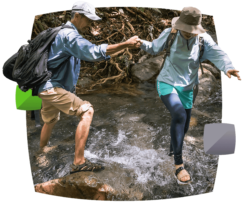 couple walking over rocks in water