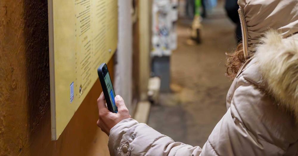 woman scanning QR code outside restaurant